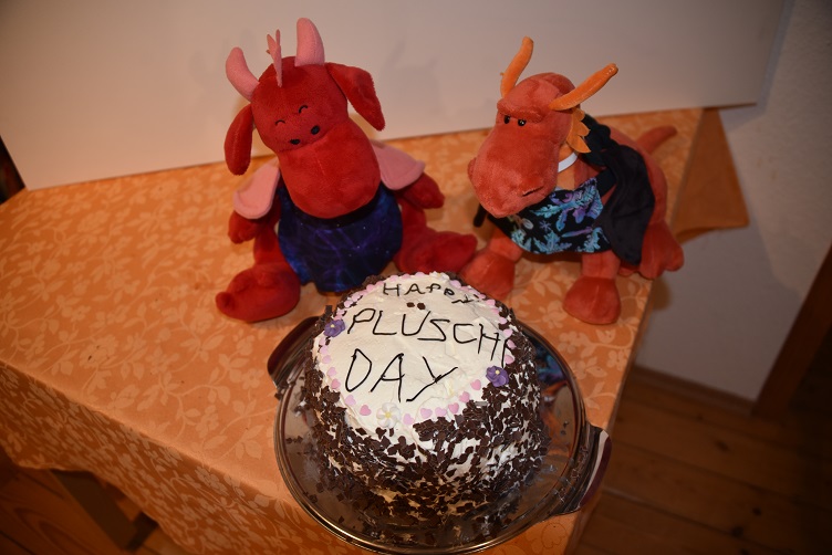 Eldur und Rosa haben die Torte mit der Aufschrift Happy Plüschi Day fertiggestellt