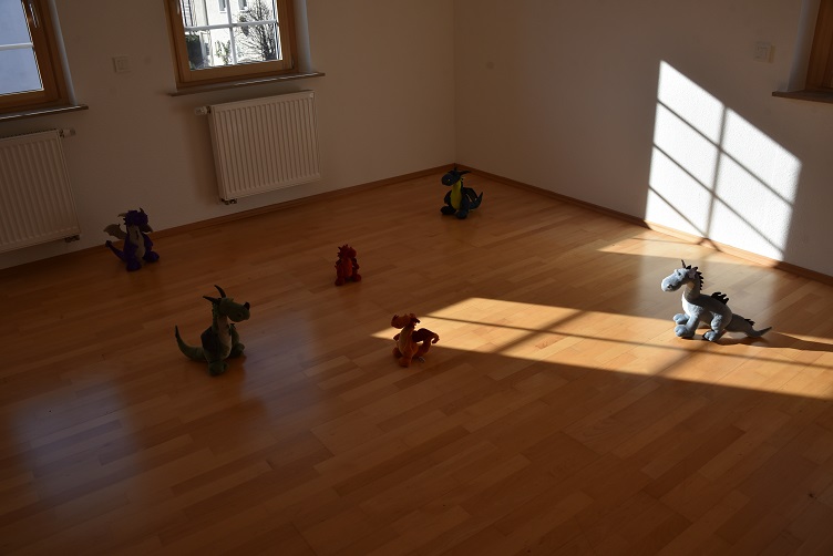Die Drachis spielen Fangen in einem leeren Zimmer