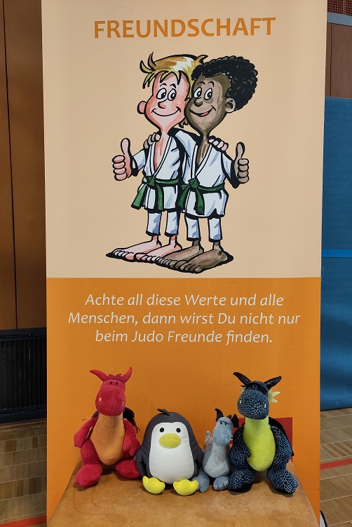 Plüschis vor Banner mit dem Judowert Freundschaft