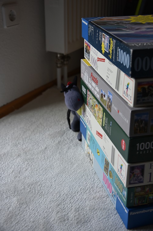 Luna versteckt sich hinter Puzzlekartons