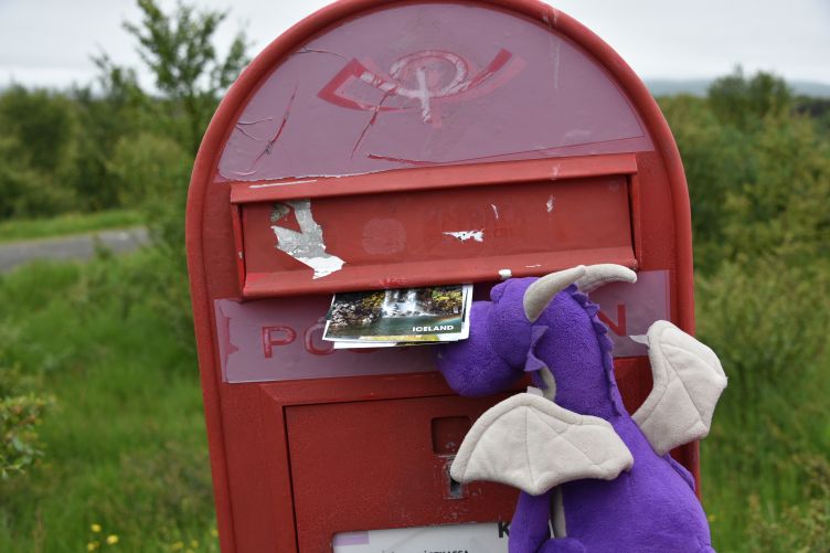 Violetta wirft Postkarten in einen Briefkasten