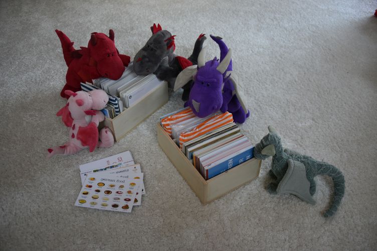 Bella, Ruby, Dracon, Violetta und Ivy schauen die Postkartenkistchen nach passenden Postkarten durch