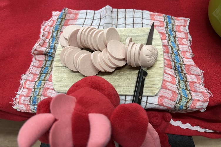 Rosa schneidet Fleischwurst