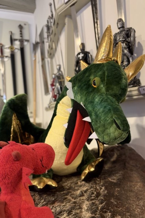 Flämmchen unterhält sich mit einem Plüschdrachen im Souvenirshop